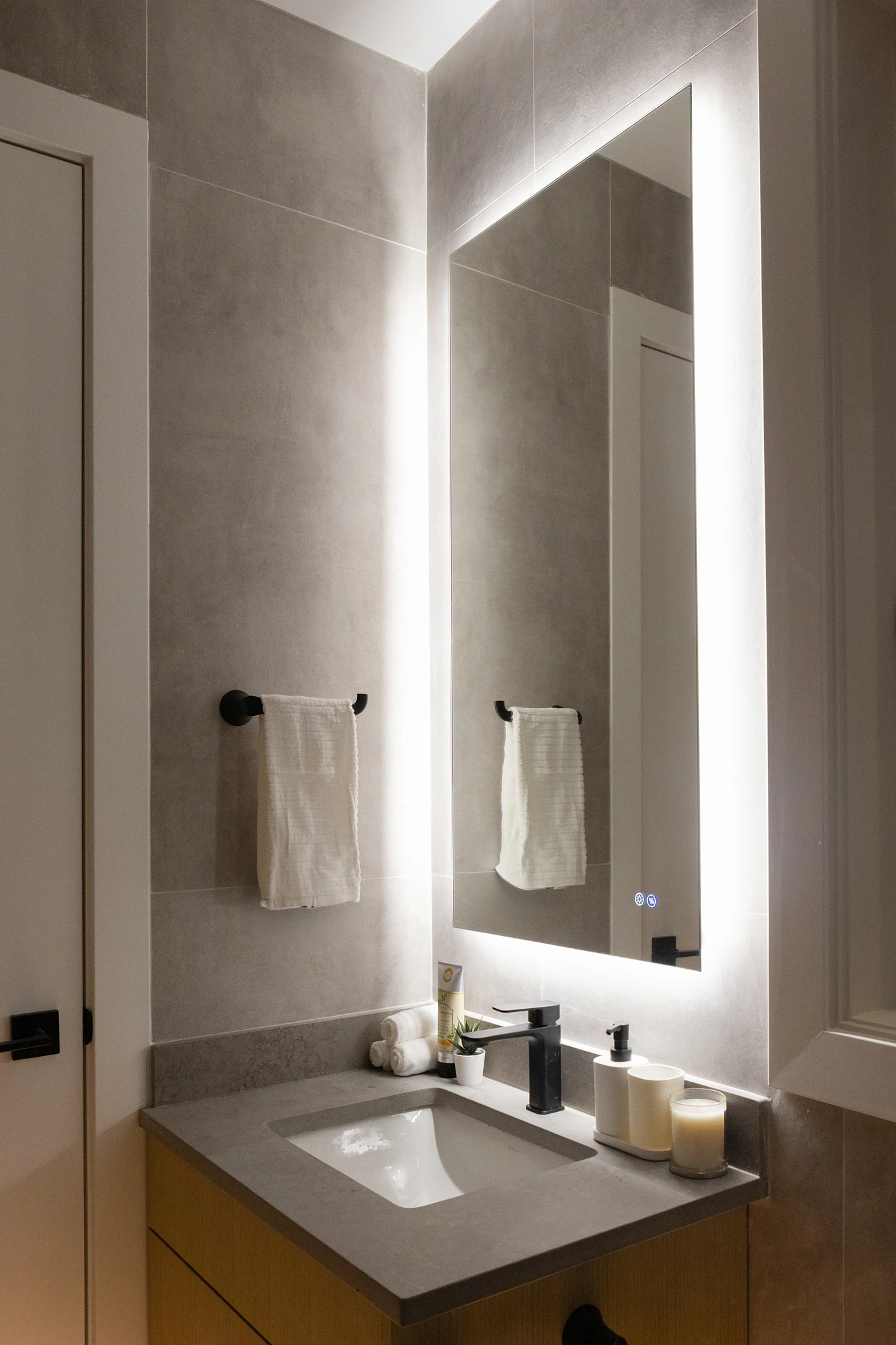 A bathroom with a sink, mirror, and towel rack.