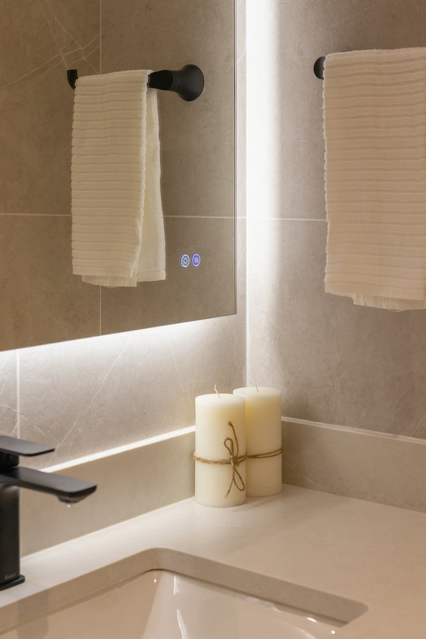 A bathroom with a mirror and two candles.