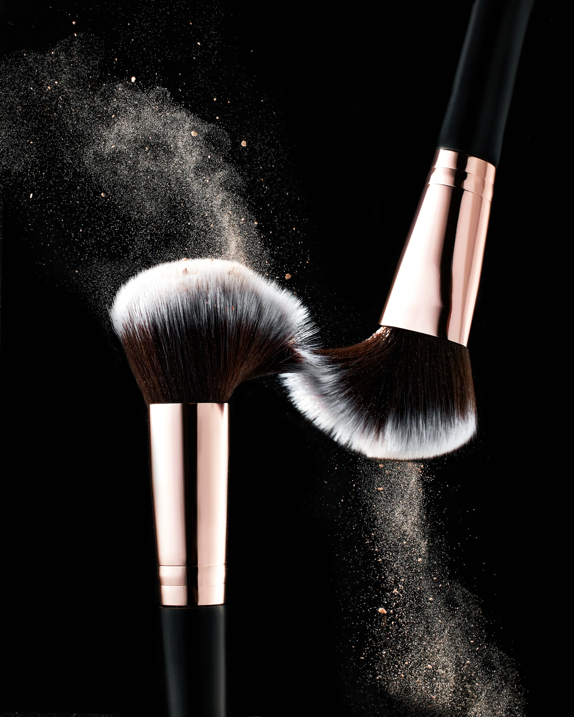 A pink and white brush with a dusting of powder on it.
