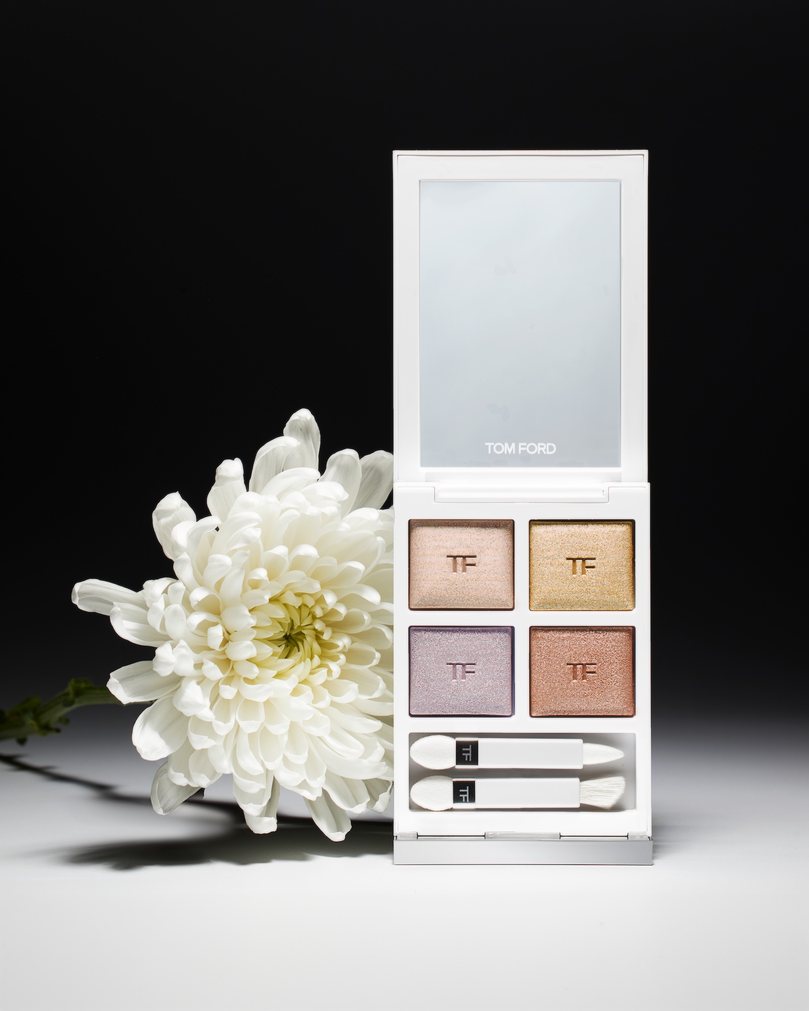 A white box with a flower and a Tom Ford makeup kit.