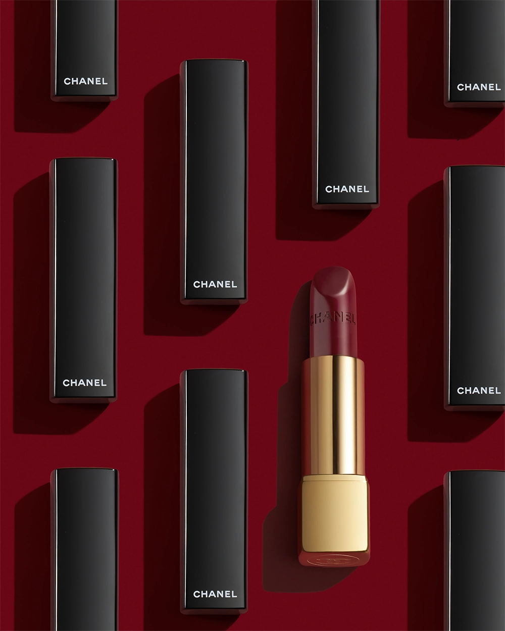 A red lipstick is in front of a row of black boxes.