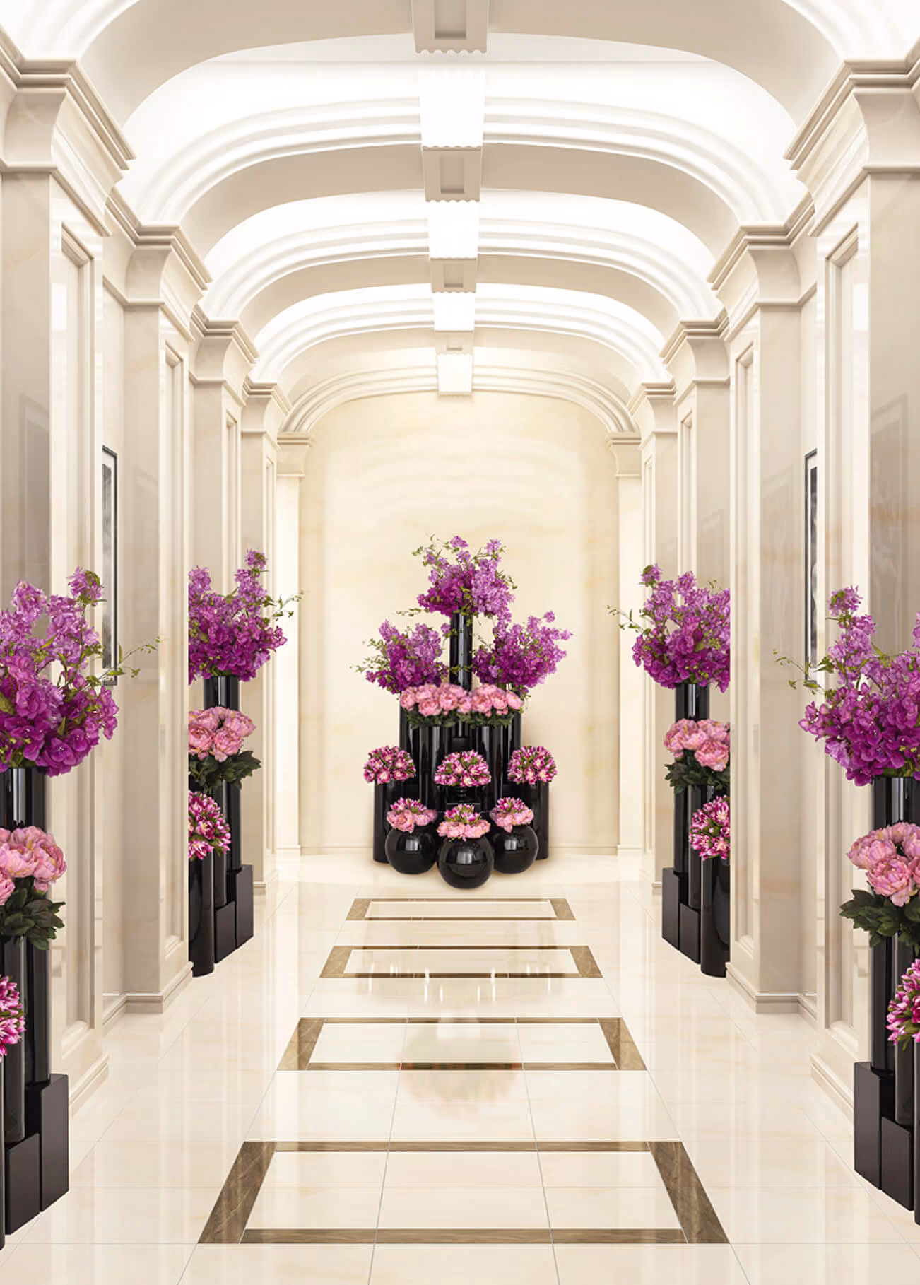 Elegant hallway with arched ceiling and black vases of pink and purple flowers along the walls and end.