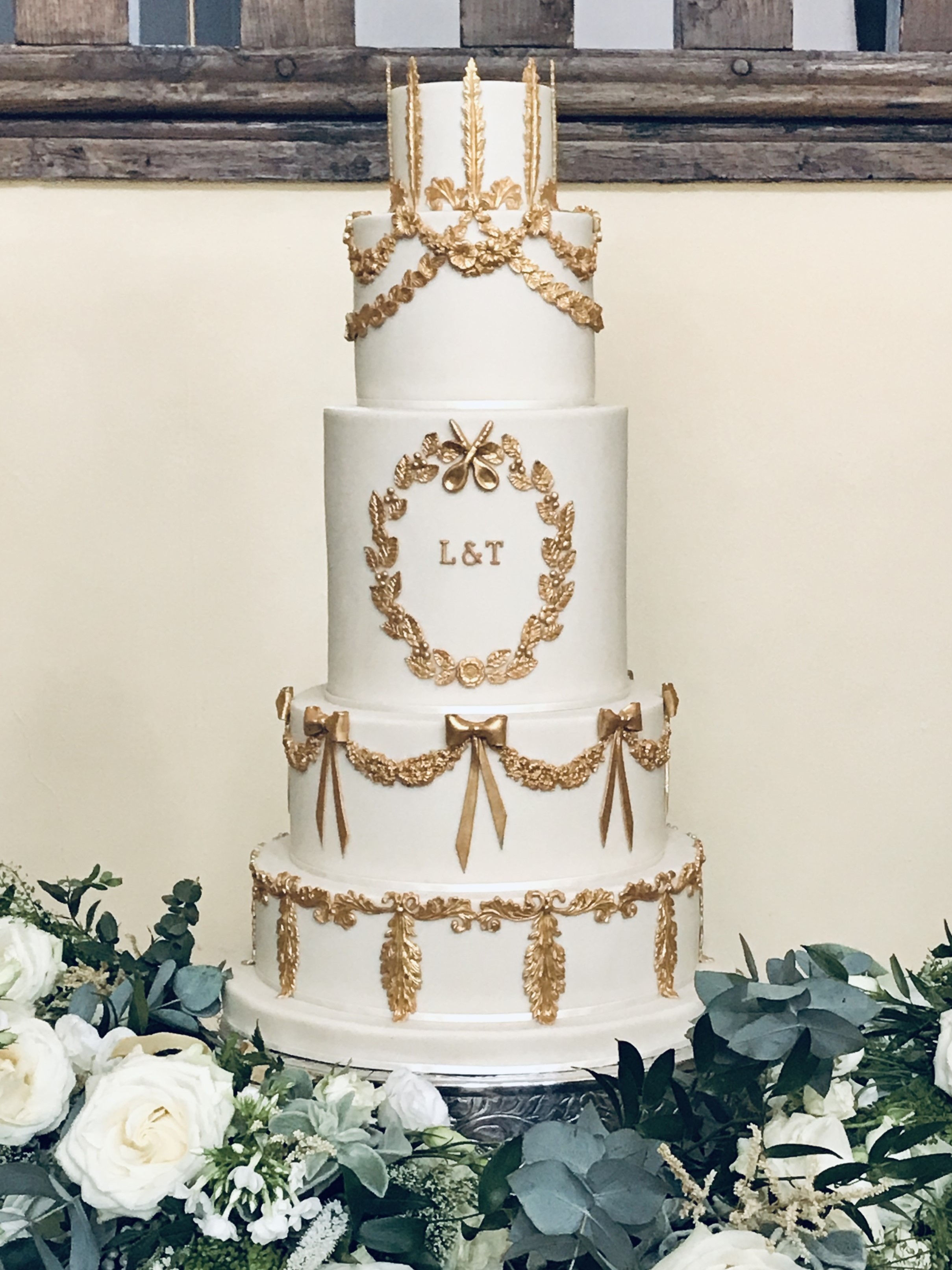 5-tier ivory wedding cake with molded gold rococo style ornaments