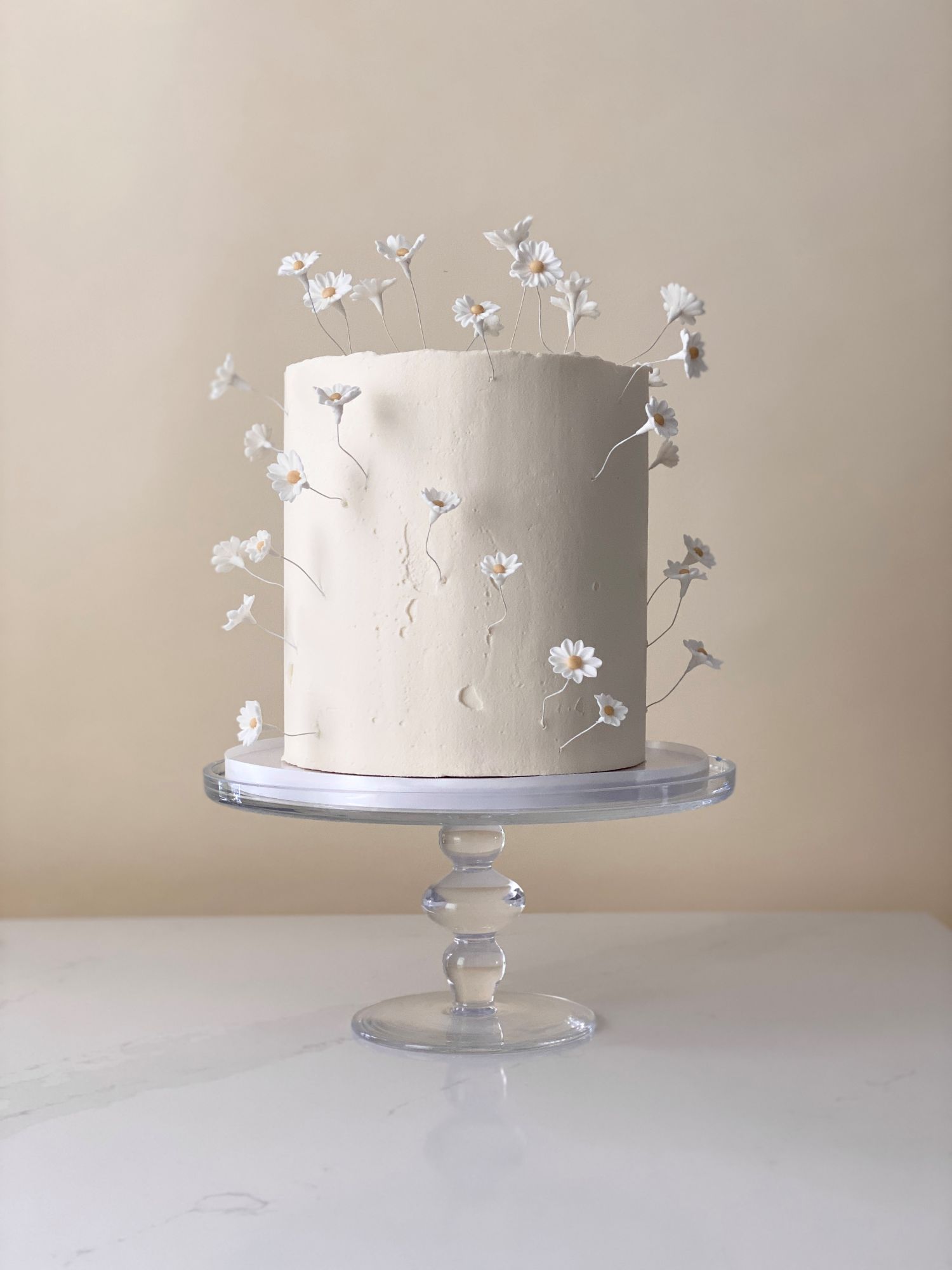 Beautiful tall wedding cake with delicate handcrafted sugar daisies. 