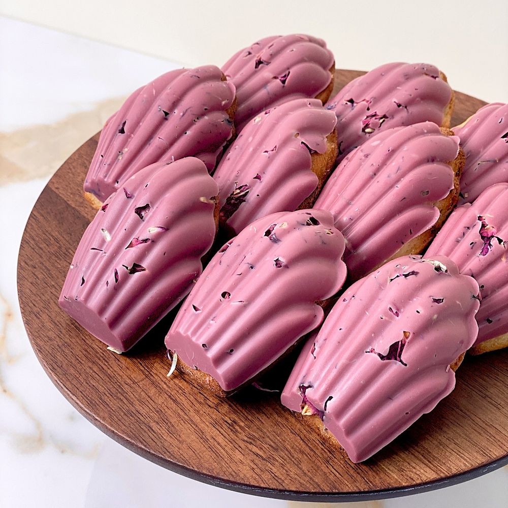 Honey madeleines with baked in blueberries and floral Ruby chocolate coat