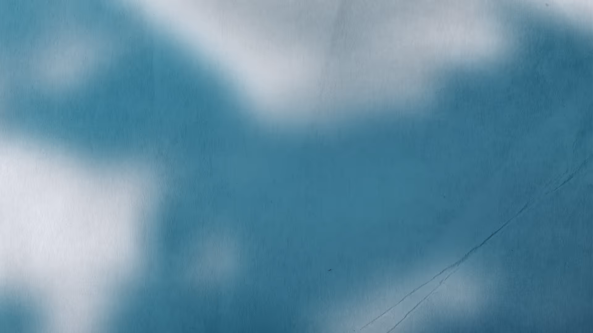 Blurred abstract shadow shapes in blue and white tones.