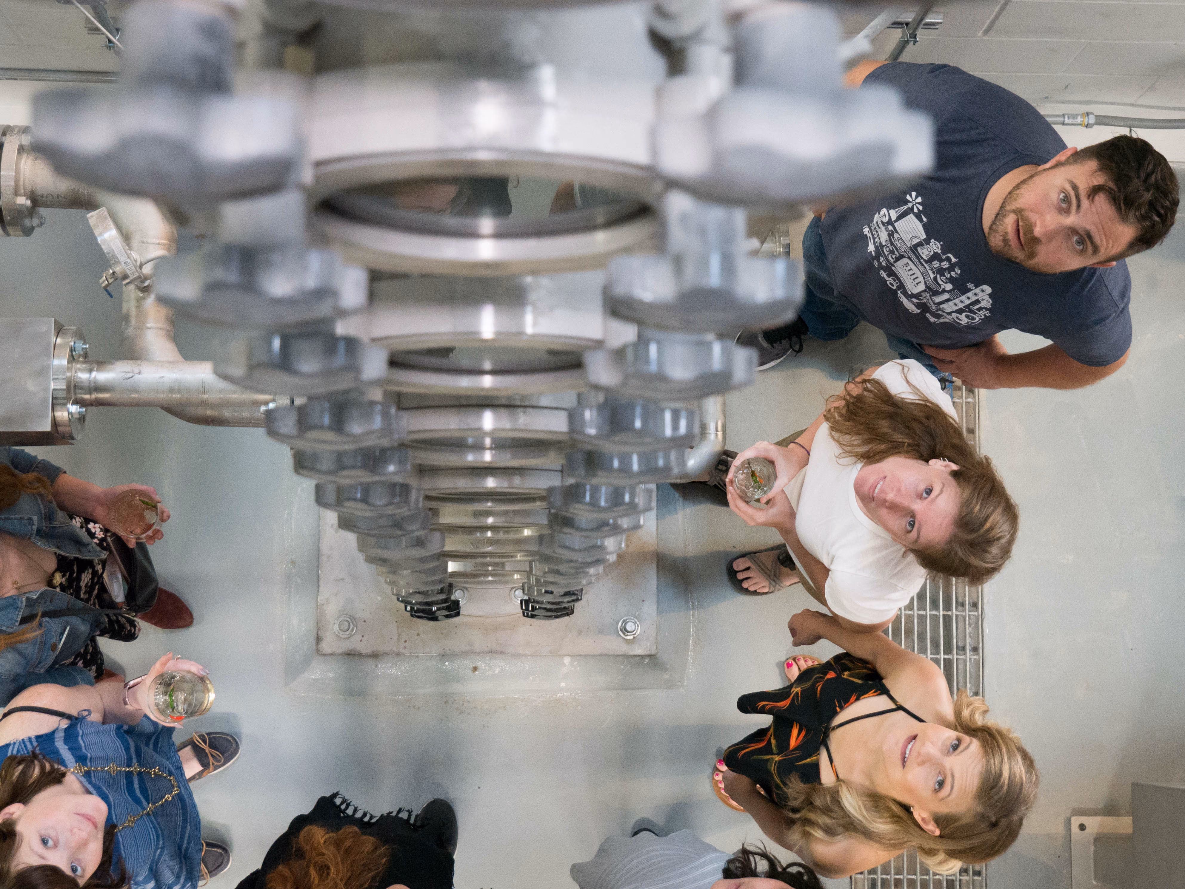 Visitors looking up at the copper column still on a distillery tour