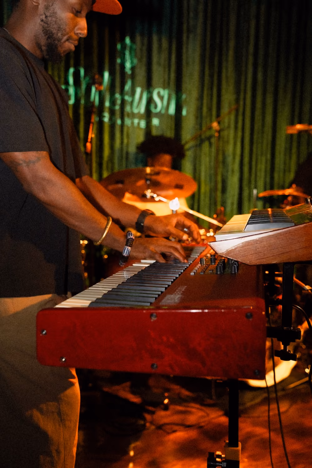 A musician playing a red keyboard on the Music Room stage