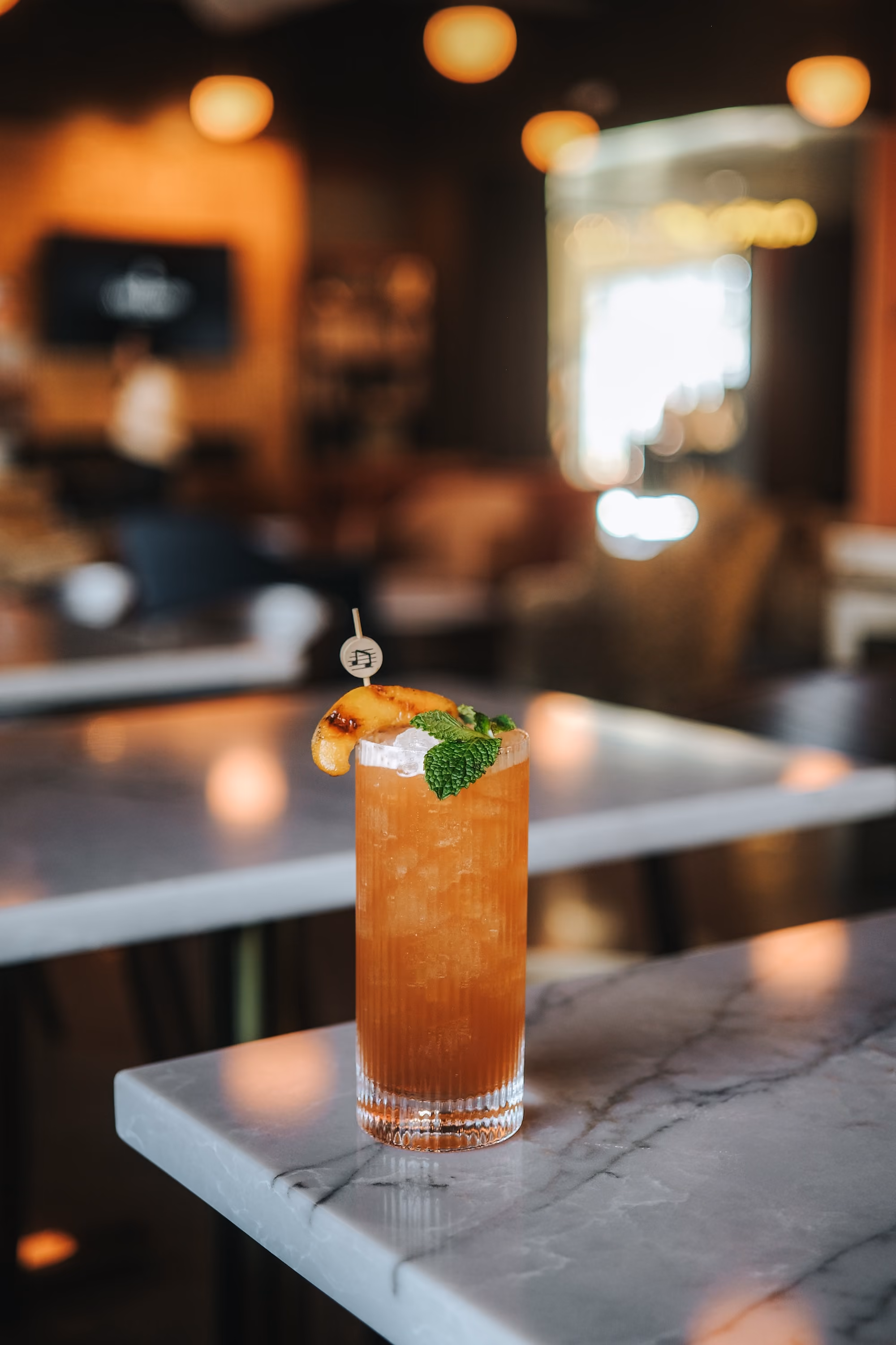 Bourbon Iced Tea garnished with mint and grilled peach