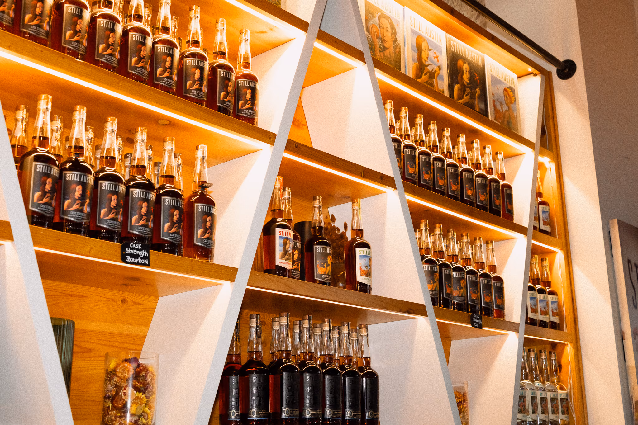 Backlit shelves of Still Austin bottles in the Bottle Shop