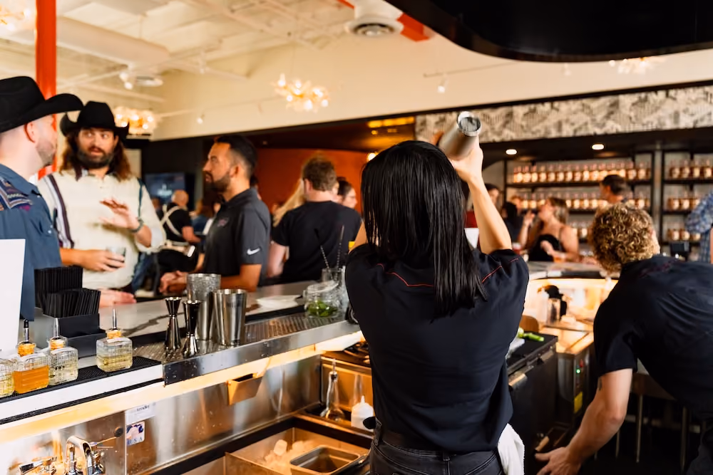 A bartender shaking a cocktail at the busy Atrium bar