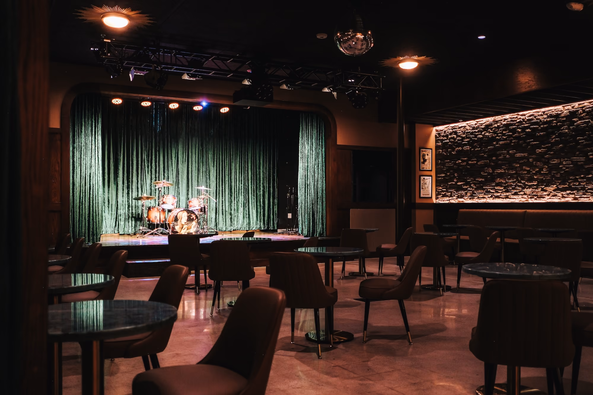 The Music Room stage with green velvet curtains and a drum kit