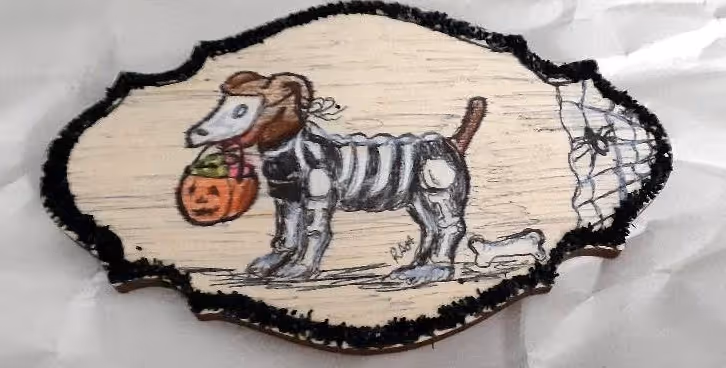 Wood sign with a dog in a skeleton costume holding a pumpkin bucket with spiderweb and bone.