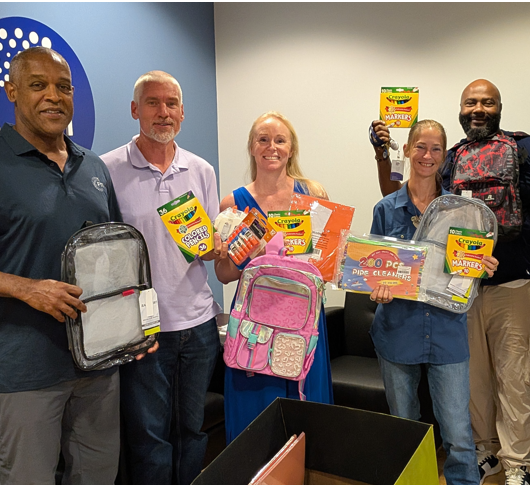 FTI Defense employees pack back to school supplies.