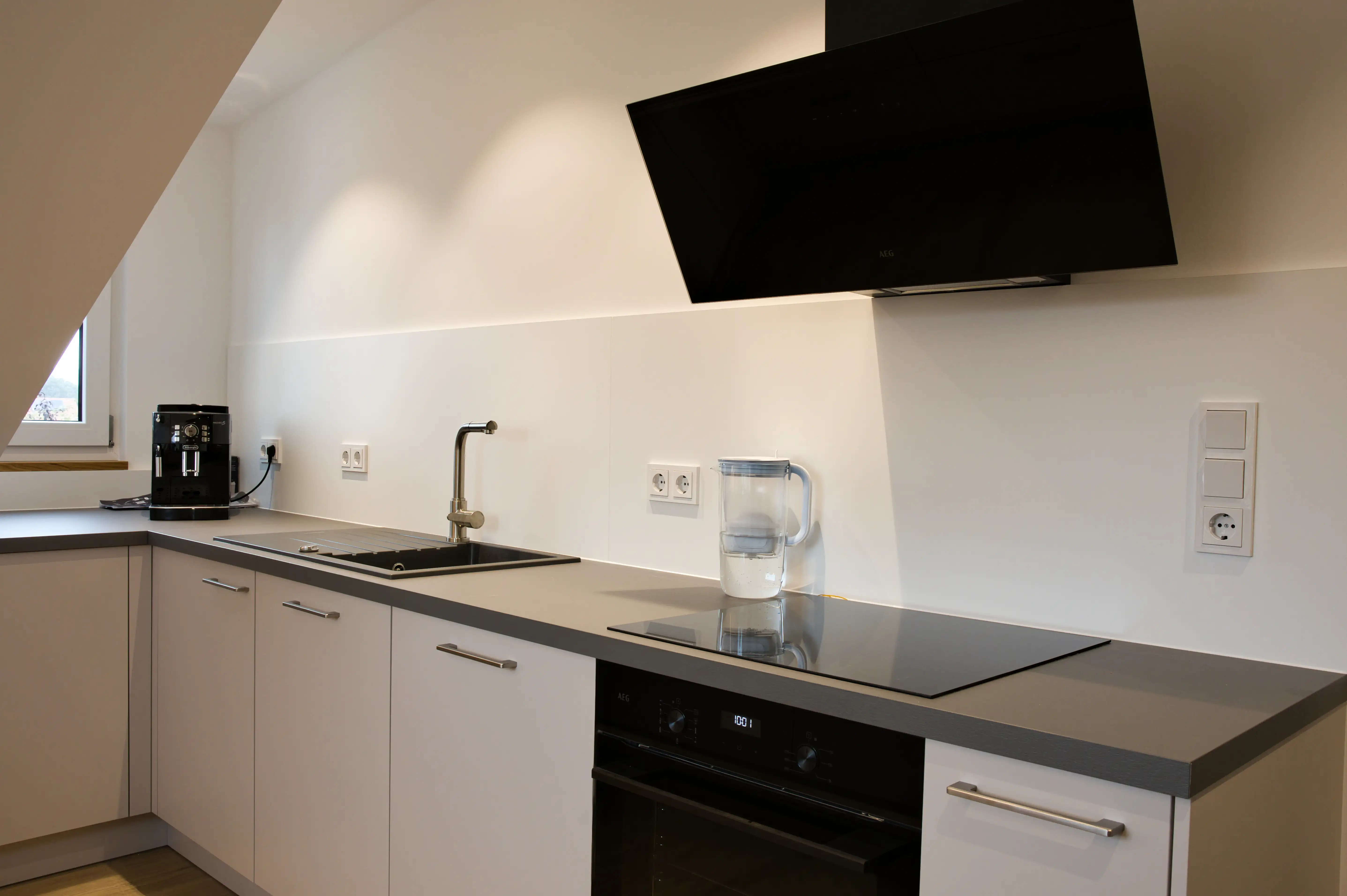 Küche mit klassischer Herd-Kombination für mehr Stauraum. Moderne Planung mit AEG-Geräten vom Thoki Küchenstudio am Wörthsee.
