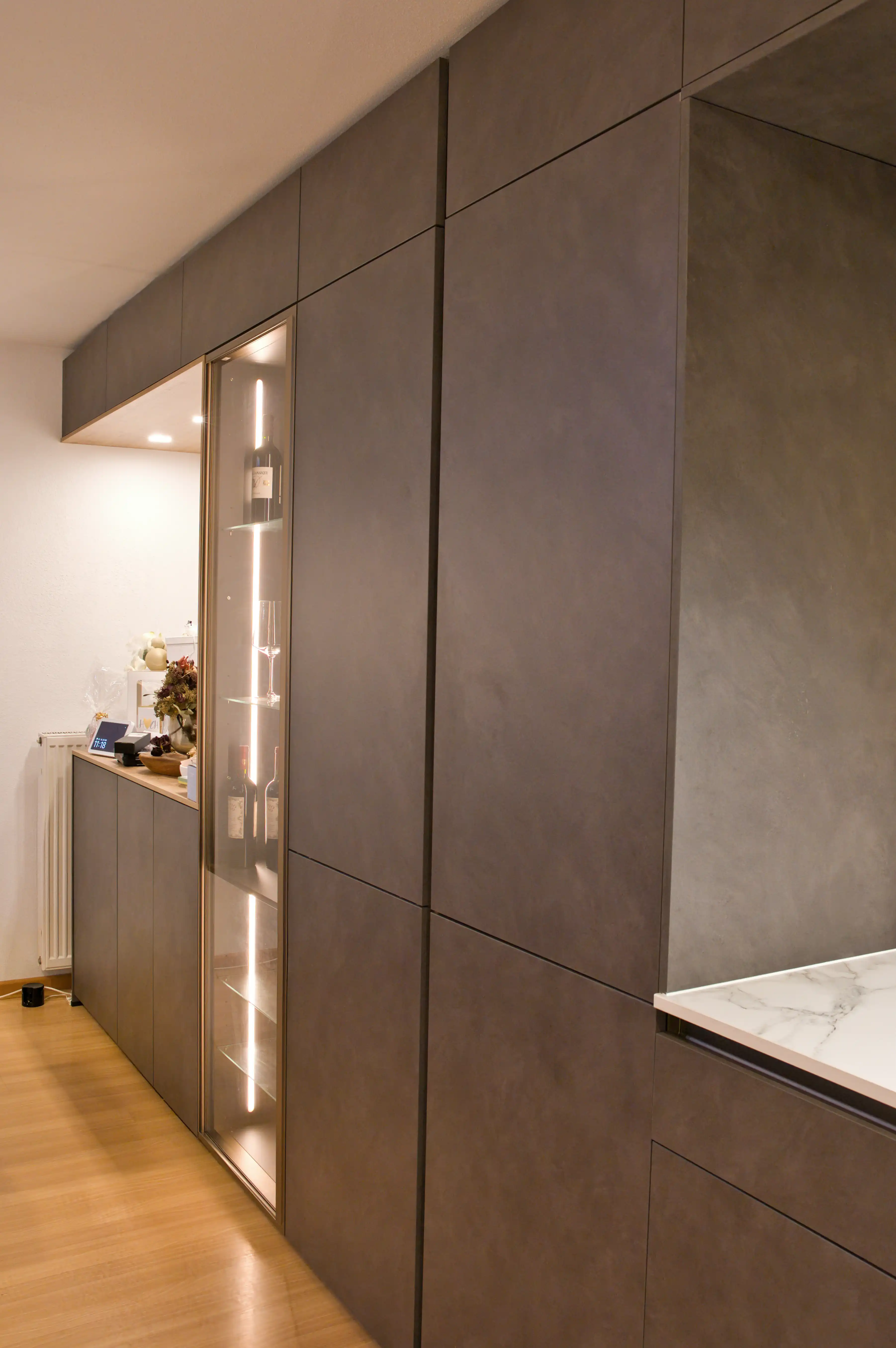 Offene moderne Küche mit eleganter Vitrine und Kaffeenische. Harmonisch geplant für fließenden Übergang zum Wohnbereich vom Thoki Küchenstudio am Wörthsee.