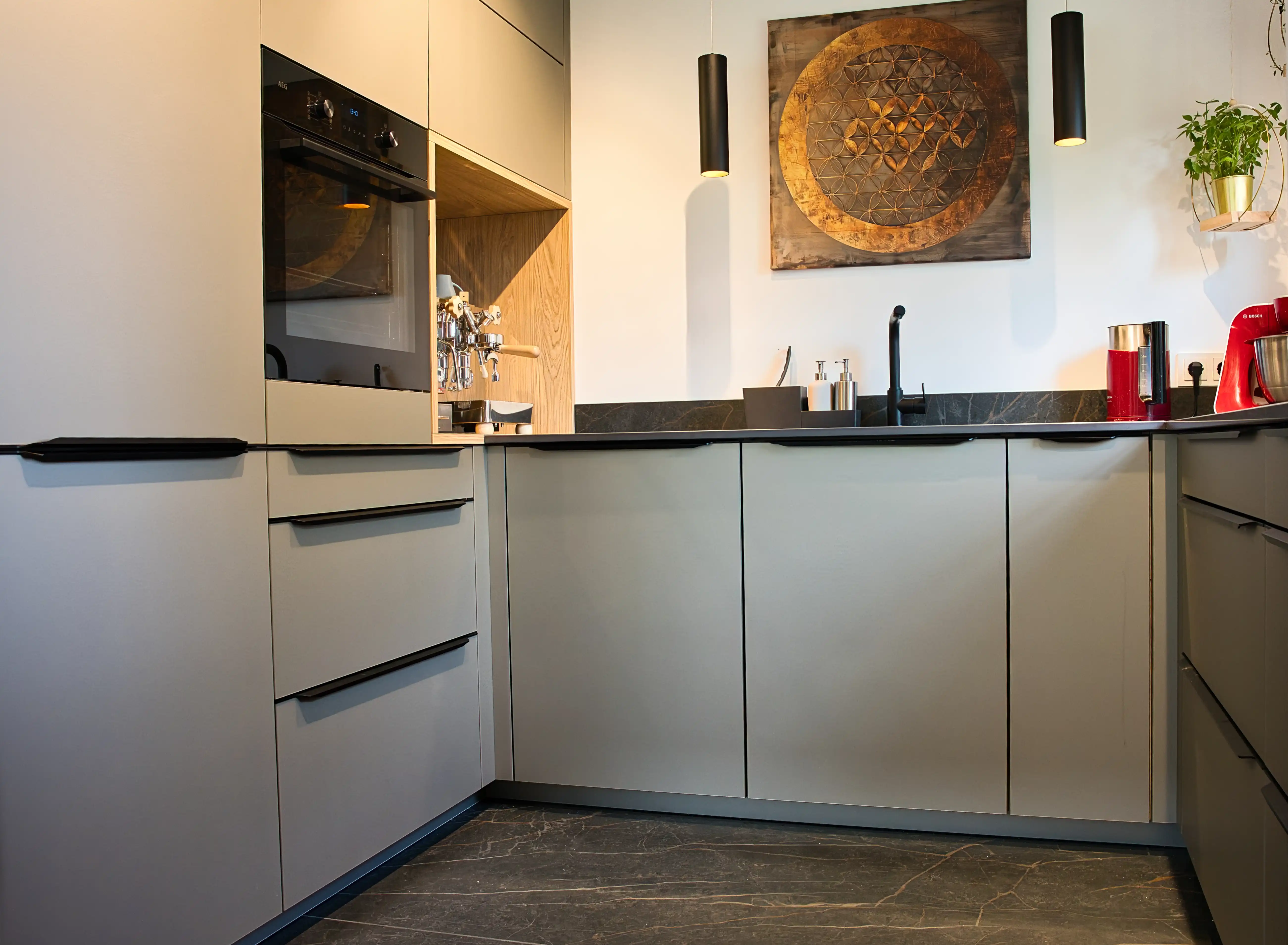 Moderne Küche mit harmonischem Materialkonzept. Die Arbeitsplatte und der Boden bestehen aus dem gleichen Material. Planung und Umsetzung durch Thoki Küche nahe München.