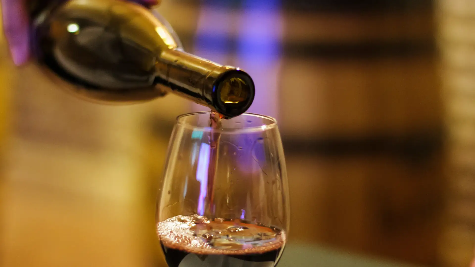 Rotwein wird in ein Rotweinglas ausgeschenkt