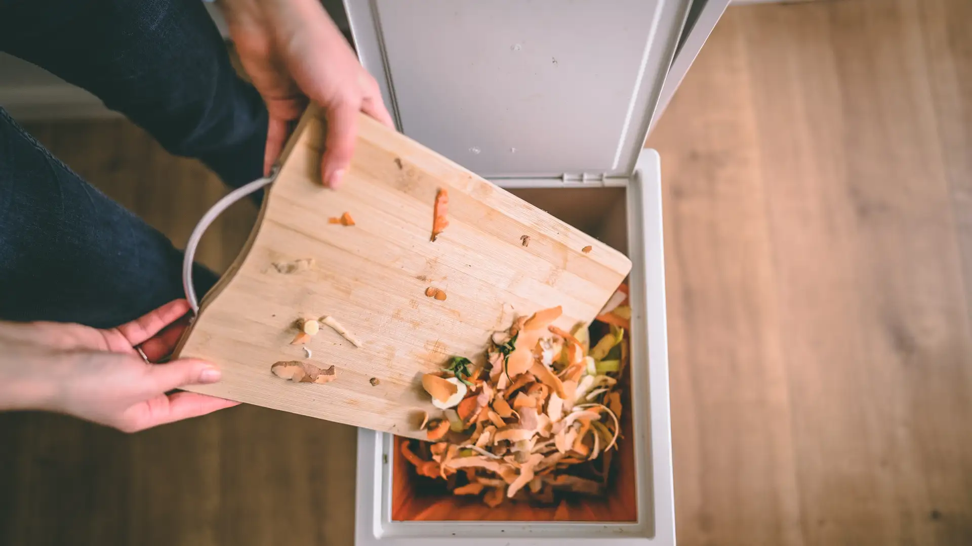 Küchenabfälle werden in einem weißen Mülleimer entsorgt