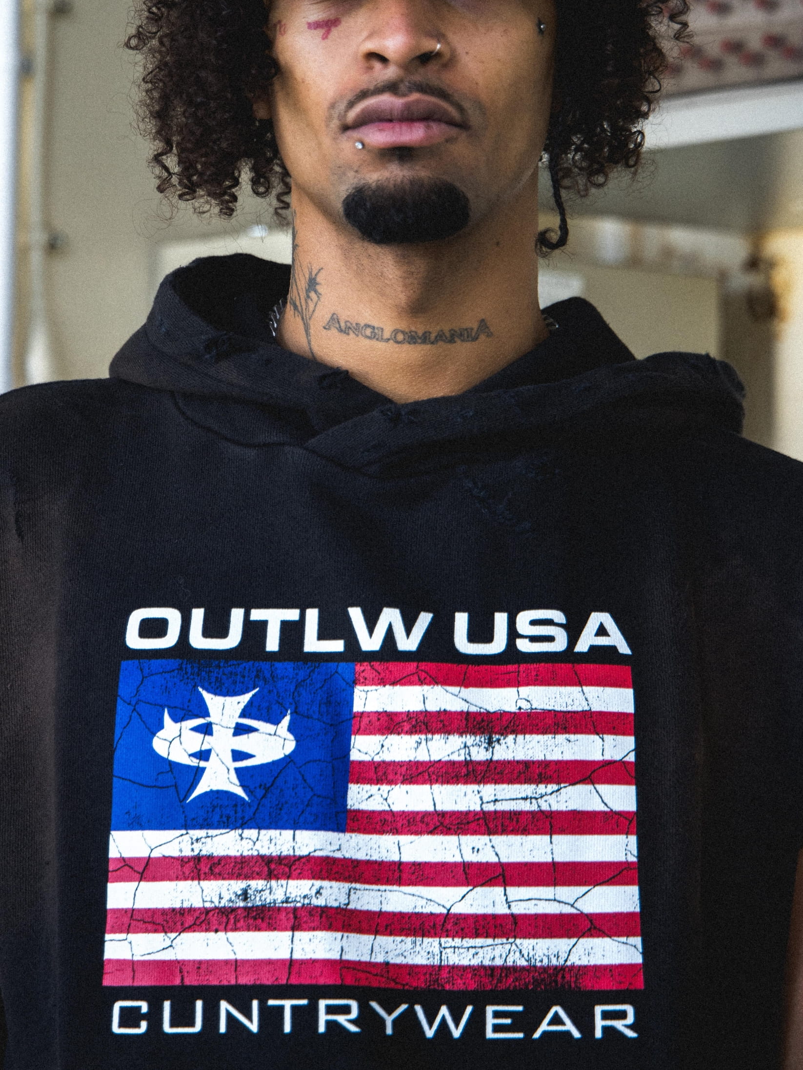 Streetwear photoshoot featuring OUTLW USA clothing on model in urban setting