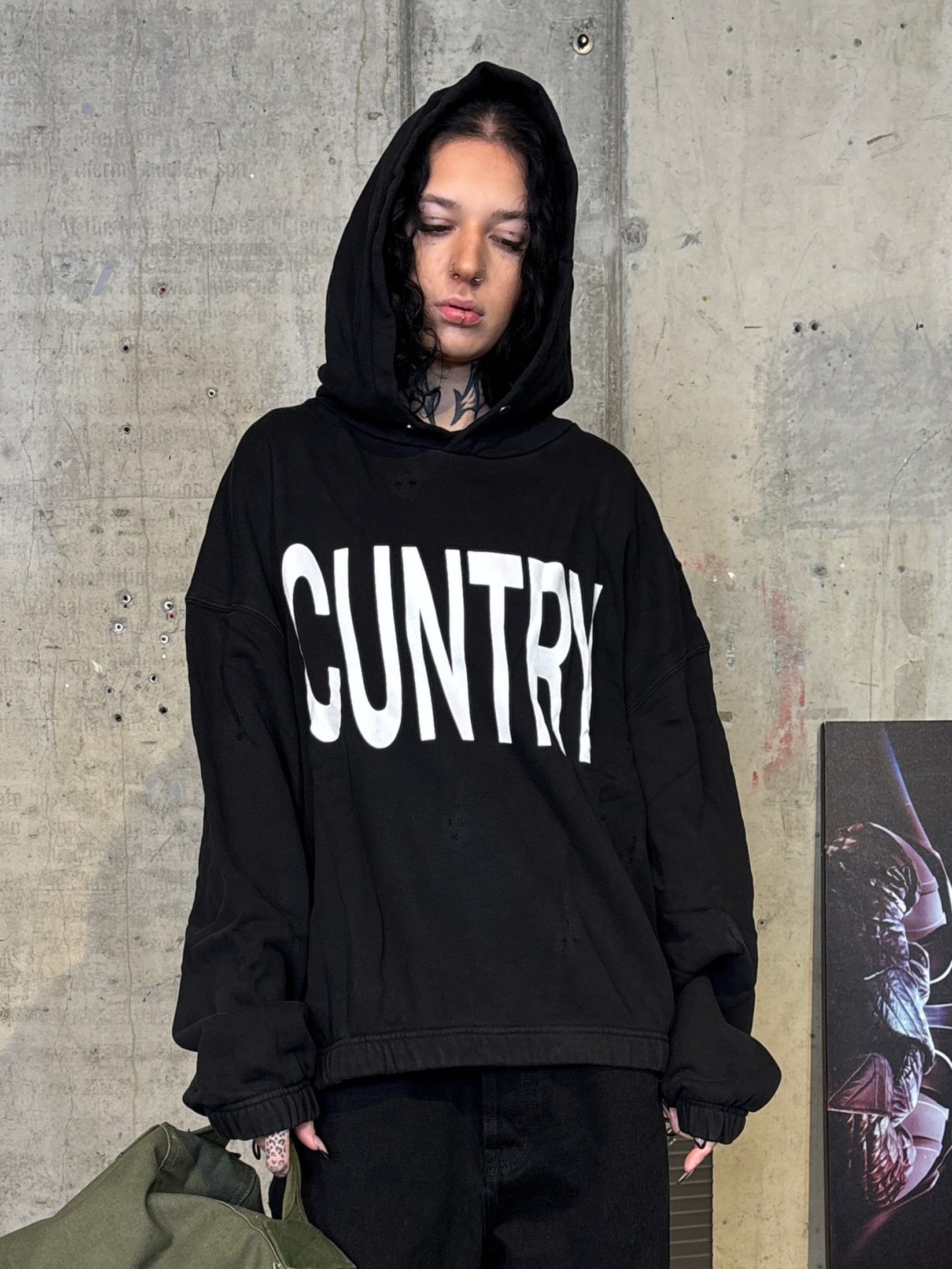 Black streetwear hoodie with worn‑effect detailing and CUNTRY graphic print