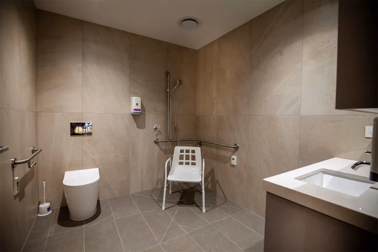 Wide view of spacious bathroom with shower, basin and toilet