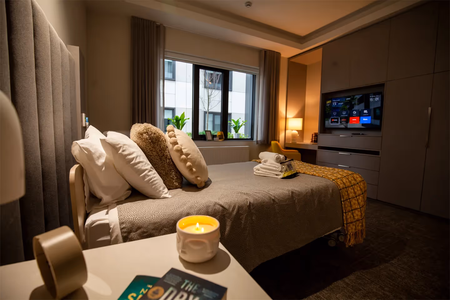Luxurious aged care room with dim lighting set with bed and TV