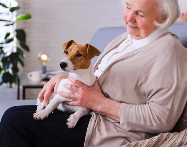 Oxa Care resident with a small dog on her lap