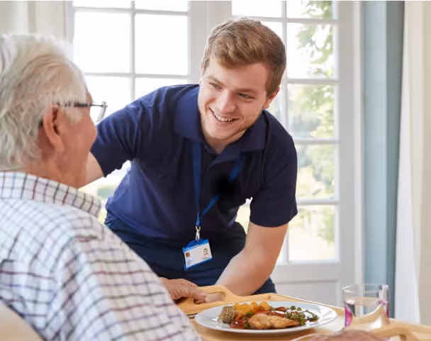 Oxa Care nurse assisting elderly resident with food