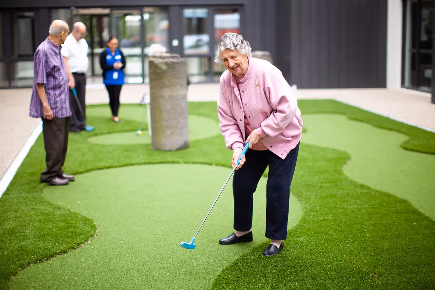 Oxa Care's outdoor golf putting green being used by residents