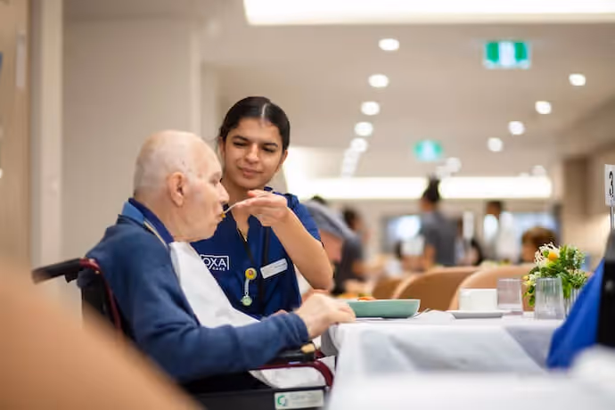 Nurse helping an elderly gentleman eat