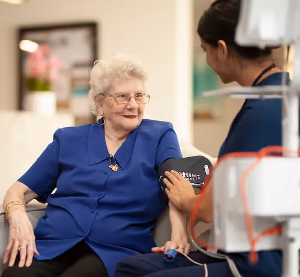 Registered nurse taking a resident's blood pressure