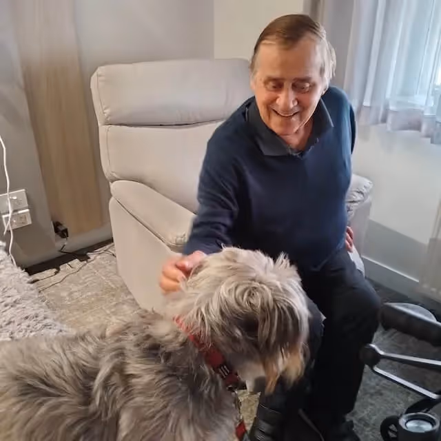 Oxa resident stroking a dog