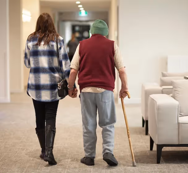 Resident and family member walking up the corridor