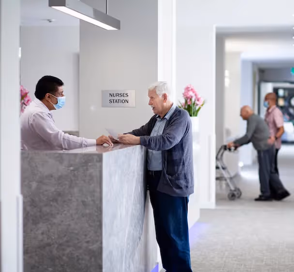 Resident speaking to a care team member at reception