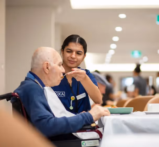Staff member helping a resident eat