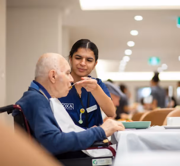 Staff member helping a resident eat