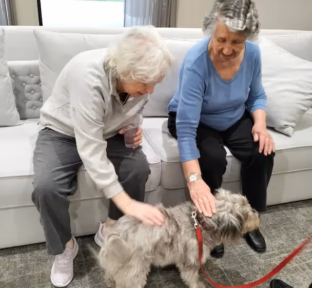Two residents enjoying pet therapy
