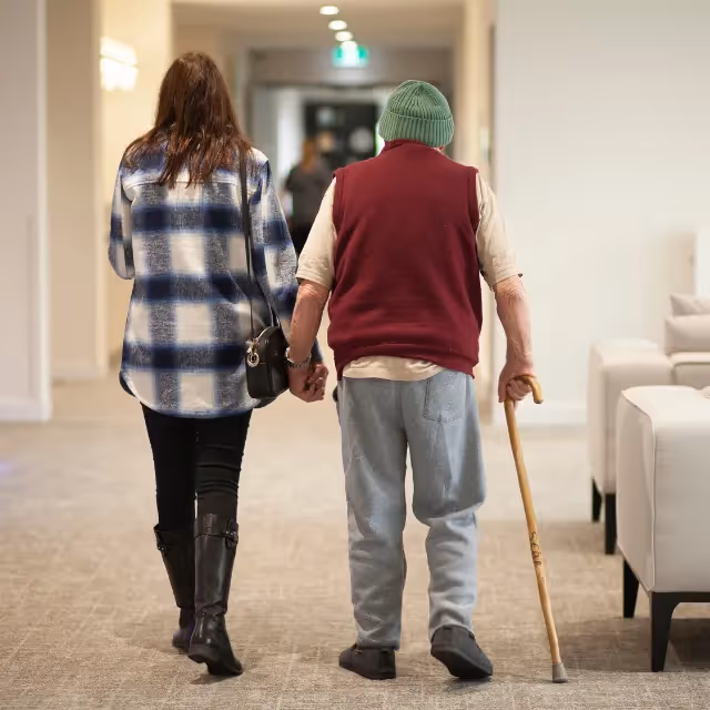 Elderly resident being supported while walking