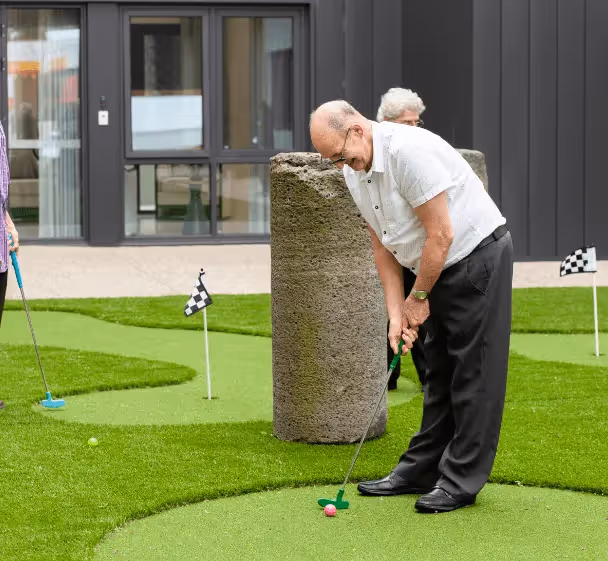 Elderly resident enjoying golf with other residents