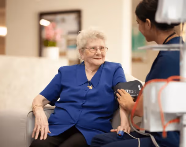 Staff member checking blood pressure of resident 