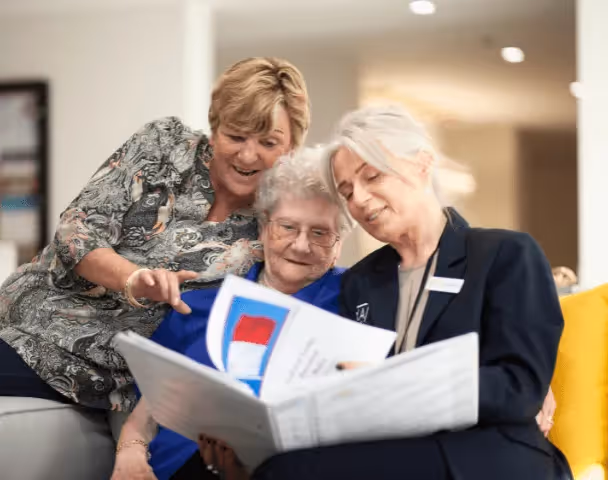Staff members helping an elderly resident 