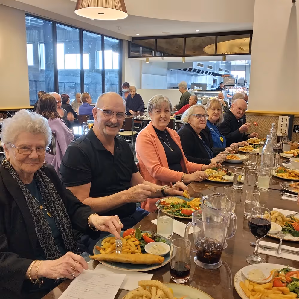 Wollert residents and families sharing a group meal together at Oxa Care, highlighting the community spirit and social lifestyle supported by our aged care services.