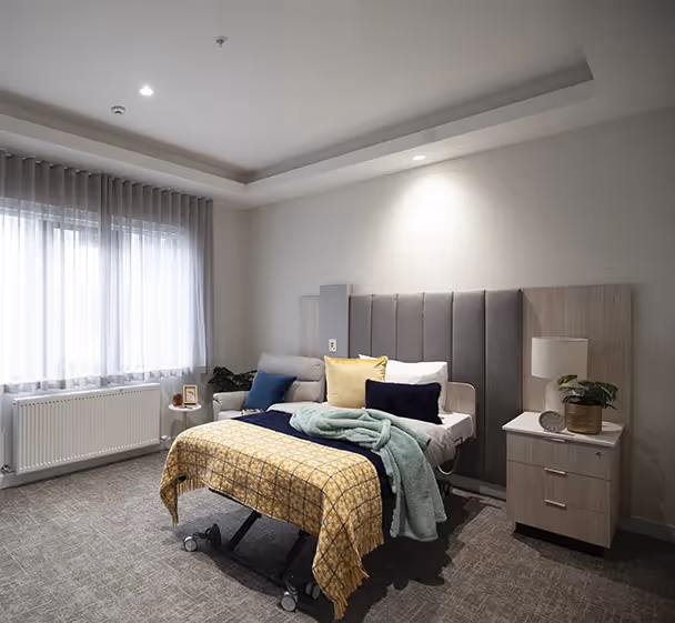 Spacious private room in Plenty aged care facility featuring a high-comfort bed, private ensuite, and soft furnishings for resident wellbeing.