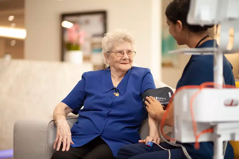 An elderly person with dementia receiving a caring medical check-up, ensuring their health and comfort with support.