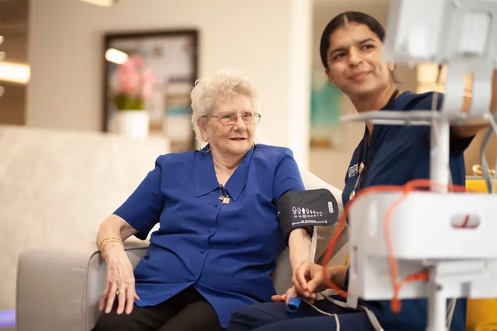 An elderly person with dementia receiving a caring medical check-up, ensuring their health and comfort with support.