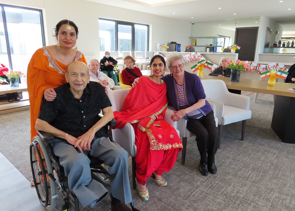 Aged care residents and carers celebrating cultural diversity, with Indian flags and traditional dress displayed throughout the facility.