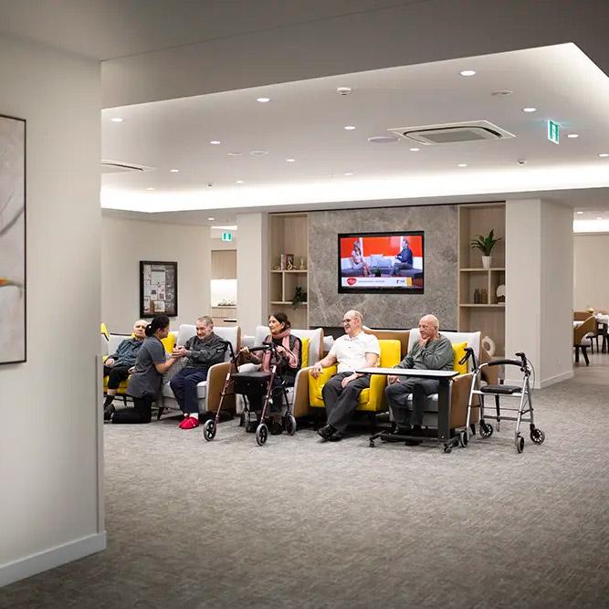 Residents relaxing together in a spacious communal lounge area at Oxa Care.