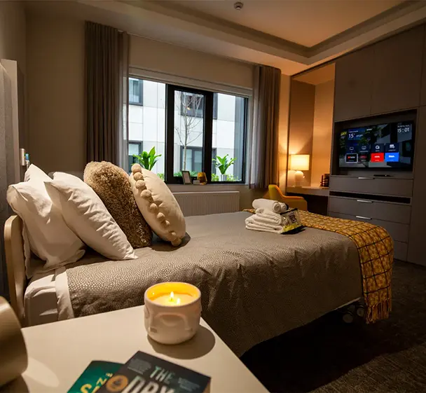 A cosy private room in an aged care residence with a bed, television and comfortable furnishings.