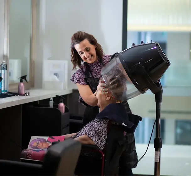 Resident having their hair styled in the on-site salon at Oxa Care.